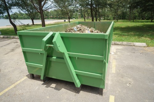 Construction workers loading waste into a skip